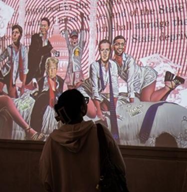 Student studies artwork projected on the wall