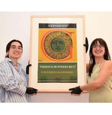 Irene Castilla and Camila Aguayo hold up a piece of Latinx art