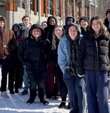 Students take a group photo outside of the Frick Environmental Center
